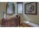 Elegant powder room with ornate vanity and unique mirror at 7546 E High Point Dr, Scottsdale, AZ 85266