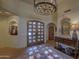 Elegant entryway with a large chandelier and double wooden doors at 7546 E High Point Dr, Scottsdale, AZ 85266