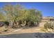 Single-story home with desert landscaping and a large driveway at 7546 E High Point Dr, Scottsdale, AZ 85266