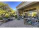 Large patio with comfortable seating and desert landscaping at 7546 E High Point Dr, Scottsdale, AZ 85266