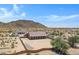 Aerial view of a house with a covered patio in a desert setting near mountains at 8474 W Switchback Trl, Casa Grande, AZ 85194