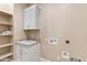 Bright laundry room with white cabinets and granite countertop at 8474 W Switchback Trl, Casa Grande, AZ 85194