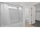 Bathroom featuring a shower-tub combination with glass doors and tiled walls, plus a toilet and door at 914 E Ross Ave, Phoenix, AZ 85024