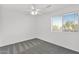 Bright bedroom with a ceiling fan, neutral carpet, and a large window offering outdoor views at 914 E Ross Ave, Phoenix, AZ 85024