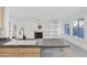 Spacious kitchen featuring a tiled countertop and stainless steel dishwasher overlooking the living room at 914 E Ross Ave, Phoenix, AZ 85024