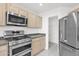 Close-up of kitchen featuring stainless steel appliances and light wood cabinets at 914 E Ross Ave, Phoenix, AZ 85024