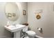 Elegant bathroom with pedestal sink, oval mirror, and decorative accents at 1081 W Danish Red Trl, San Tan Valley, AZ 85143