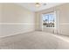 Inviting bedroom with neutral walls, plush carpeting, and bright natural light from a large window at 1242 E Bartlett Way, Chandler, AZ 85249