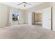 Spacious carpeted bedroom with a ceiling fan and an abundance of natural light from the large window at 1242 E Bartlett Way, Chandler, AZ 85249