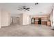 Open living room with adjacent kitchen features neutral paint and carpet and a ceiling fan at 1242 E Bartlett Way, Chandler, AZ 85249