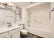 Bright bathroom featuring a tiled floor, a skylight, and a tub with accessibility safety bars at 18852 N Aztec Dr, Sun City, AZ 85373