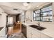 Bright kitchen with white cabinets and countertops, stainless steel appliances, and views of the living space at 18852 N Aztec Dr, Sun City, AZ 85373