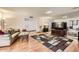 Bright living room featuring laminate floors, a decorative rug, and a mirrored wall at 18852 N Aztec Dr, Sun City, AZ 85373