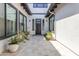 Private courtyard entry with a modern dark brown front door and potted plants at 21961 E Via De Arboles St, Queen Creek, AZ 85142