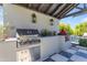 Outdoor kitchen with built-in grill and checkerboard patio at 21961 E Via De Arboles St, Queen Creek, AZ 85142