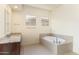 Bathroom with granite vanity, soaking tub, and neutral tile at 22665 E Stacey Rd, Queen Creek, AZ 85142