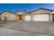 Tan three-car garage home with a paved driveway and desert landscaping at 22665 E Stacey Rd, Queen Creek, AZ 85142