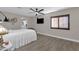 Main bedroom with white bedding, ceiling fan, and large window at 2366 E Becker Ln, Phoenix, AZ 85028