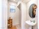 Clean and simple bathroom with pedestal sink and wood accent cabinet at 25210 N 54Th Dr, Phoenix, AZ 85083