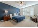 Spacious bedroom with blue bedding and wood furniture at 25973 W Horsham Dr, Buckeye, AZ 85396