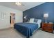 Bright bedroom with blue bedding and a view of the bathroom at 25973 W Horsham Dr, Buckeye, AZ 85396