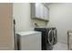 Laundry room with washer, dryer, and extra storage at 25973 W Horsham Dr, Buckeye, AZ 85396