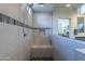 Walk-in shower with built-in seat and gray tile at 25973 W Horsham Dr, Buckeye, AZ 85396