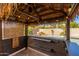 Covered tiki bar with seating, lights, and a dart game. Perfect for entertaining at 3552 E Claxton Ave, Gilbert, AZ 85297