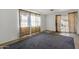 Living room with gray carpet, sliding glass door and floral curtains at 3821 W Verde Ln, Phoenix, AZ 85019