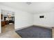 Living room with gray carpet, view into kitchen and shelving at 3821 W Verde Ln, Phoenix, AZ 85019