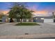 Gray stucco house with mature tree and well manicured lawn at 5429 E Bloomfield Rd, Scottsdale, AZ 85254