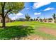 Spacious green lawn with mature trees and community buildings in the background at 6820 S Rita --, Tempe, AZ 85283