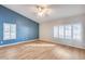 Bedroom with blue accent wall, wood-look floors, and plantation shutters at 7132 W Villa Chula --, Glendale, AZ 85310