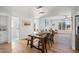 Bright dining area with rustic wooden table and bench, hardwood floors, and view into kitchen and bathroom at 7501 N 22Nd Pl, Phoenix, AZ 85020