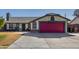 Single story home with a red garage door, landscaping, and basketball hoop at 7945 W Wethersfield Rd, Peoria, AZ 85381