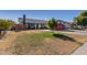 House with a large grassy yard, a red garage door, and a wooden fence at 7945 W Wethersfield Rd, Peoria, AZ 85381