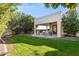 Relaxing backyard patio with seating area, grill, and grassy lawn at 8008 E Del Rubi Dr, Scottsdale, AZ 85258