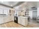 Modern white kitchen with island, stainless steel appliances, and wood-look flooring at 8008 E Del Rubi Dr, Scottsdale, AZ 85258