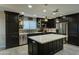 Modern kitchen with dark cabinetry, stainless steel appliances, and large island at 9136 E Plata Ave, Mesa, AZ 85212