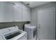 Functional laundry room with washer, dryer, and overhead cabinets at 9136 E Plata Ave, Mesa, AZ 85212