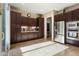 Well lit kitchen featuring stainless steel appliances, tile flooring, custom wood cabinetry, and a sliding glass door at 12935 W Lone Tree Trl, Peoria, AZ 85383