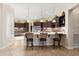 Open kitchen featuring a countertop bar with chairs, tiled floors, custom wood cabinets, and stainless steel appliances at 12935 W Lone Tree Trl, Peoria, AZ 85383