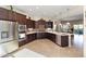 Modern kitchen with stainless steel appliances, dark wood cabinets, tile backsplash and a large center island at 12935 W Lone Tree Trl, Peoria, AZ 85383