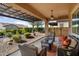 Inviting covered patio with comfortable seating and landscaped backyard view at 12935 W Lone Tree Trl, Peoria, AZ 85383