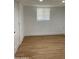 Simple bedroom with light wood flooring and a closed door at 2802 N 50Th Ln, Phoenix, AZ 85035