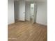Simple bedroom with wood-look floors and access to closet and hallway at 2802 N 50Th Ln, Phoenix, AZ 85035