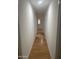 Long hallway with light walls and wood-look floors at 2802 N 50Th Ln, Phoenix, AZ 85035