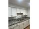 Bright kitchen with white cabinets, granite countertops, and a double sink at 2802 N 50Th Ln, Phoenix, AZ 85035