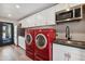 Laundry room with red washer and dryer, white cabinets, and dark countertop at 2928 E Cortez St, Phoenix, AZ 85028