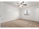 This bedroom features neutral colored walls, tan carpet and a ceiling fan at 402 E South Ave, Buckeye, AZ 85326